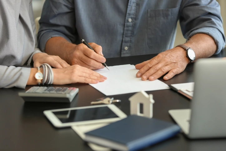 Couple signing document in estate agent's office